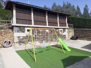 a playground with a slide and a swing at Canastro Country House in Castelo de Paiva