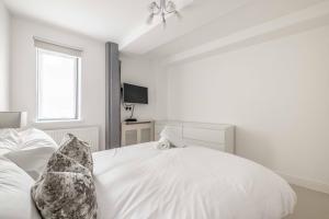 ein weißes Schlafzimmer mit einem Bett und einem Fenster in der Unterkunft Windsor Castle & High Street 2 min walk in Windsor