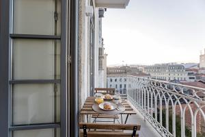 een tafel op een balkon met uitzicht op de stad bij 31 Janeiro 157 - Delightful 1BR Flat w/ AC & Balcony by LovelyStay in Porto
