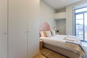 een slaapkamer met een groot bed en een raam bij 31 Janeiro 157 - Delightful 1BR Flat w/ AC & Balcony by LovelyStay in Porto