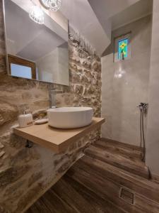 bagno con lavandino e specchio di Hall Apartments & Rooms - by Avelink a Spata