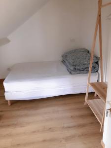 ein weißes Bett in einem Zimmer mit einer Leiter in der Unterkunft petite maison avec jardin dans banlieue de Paris in Cormeilles-en-Parisis