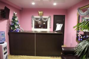 a bar in a pink room with a christmas tree at Hotel Lyuks in Arzamas