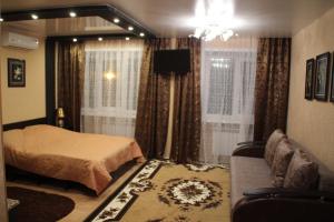 1 dormitorio con cama, sofá y ventana en Hotel Lyuks, en Arzamas