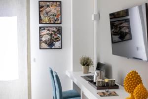 Habitación con escritorio blanco con silla azul. en La Musa Apartments & Rooms, en Palermo