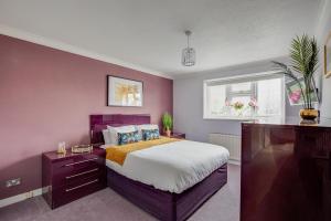 Dormitorio púrpura con cama y ventana en Ashford, Legoland, Windsor, Heathrow Serviced House en Stanwell
