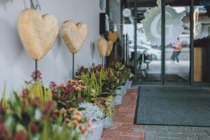 un grupo de corazones colgando de un lado de un edificio en Der Gollinger en Saalbach Hinterglemm