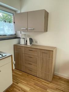 a kitchen with wooden cabinets and a counter top at Bungalow am Donaupark in Regensburg