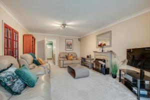 a living room with a couch and a fireplace at Ashford, Legoland, Windsor, Heathrow Serviced House in Stanwell