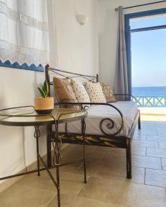 a bedroom with a bed with a table and a window at Alisachni Villas in Lefkos Karpathou