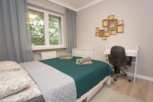 a bedroom with a bed and a desk and a chair at Duży apartament w centrum przy rynku in Białystok