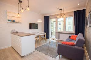 a kitchen and living room with a couch and a table at Duży apartament w centrum przy rynku in Białystok