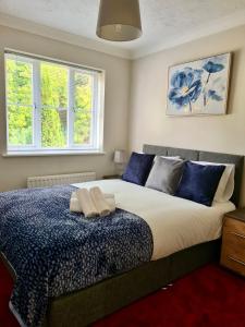 a bedroom with a large bed with blue pillows at Delight Marvel- Beech Hurst-3 bedroom house in Maidstone