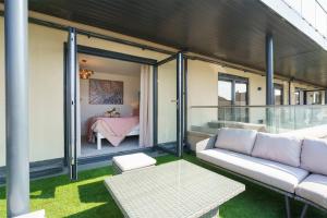 Darlington - 2 Bedroom Luxury Apartment by Mint Stays في بريستول: غرفة معيشة مع أريكة وغرفة نوم