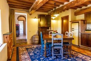 une cuisine avec une table en bois et des chaises bleues dans l'établissement Appartamento gli Archi, à Civitella Marittima