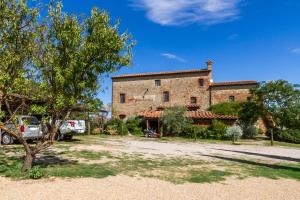 un grand bâtiment en pierre avec une voiture garée devant. dans l'établissement Appartamento gli Archi, à Civitella Marittima