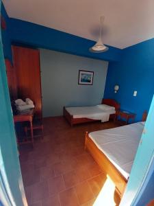 a bedroom with two beds and a blue wall at Zafira Studios in Kefalos