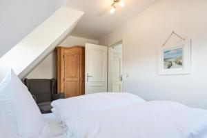 a bedroom with two white beds and a staircase at LH Dwarslöper, App 3 in Wenningstedt