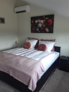 een slaapkamer met een groot bed en een schilderij aan de muur bij Gastenverblijf De Handwijzer in Hengelo