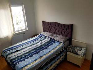 een slaapkamer met een bed met een paars hoofdeinde en een raam bij 33 Hotel two bedrooms Appartment 15 min from Istanbul airport in Habipler