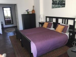 ワルシャワにあるFiesta Apartamentのベッドルーム1室(紫のシーツが敷かれた大型ベッド1台付)
