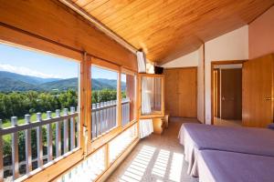 a bedroom with a bed and a balcony with mountains at Hotel Restaurante La Glorieta in La Seu d'Urgell