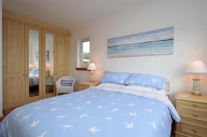 a bedroom with a blue bed with blue and white sheets at Bay View in Lochgilphead