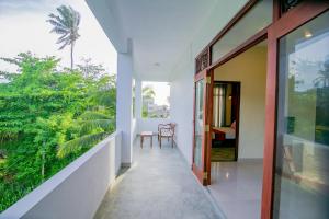 a balcony of a house with a door and a table at Athithi Villa in Hikkaduwa