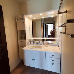 uma casa de banho com um lavatório branco e um espelho. em Le vent dans les voiles em Mèze