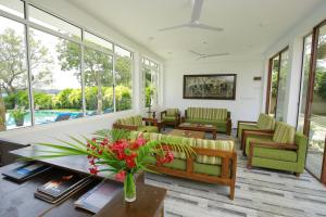 a living room with couches and a table with flowers at Diya Dahara Lake Resort in Tissamaharama