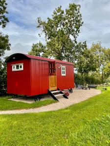 un vagón de tren rojo expuesto en un parque en Sheelin Shepherds Hut 2 with Hot Tub, en Mountnugent