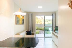 a dining room with a black table and a balcony at Aquarius Residence in Porto De Galinhas