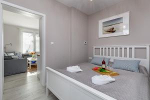 a bedroom with a bed with a tray of food on it at Seaside Apartment with Parking - Międzyzdroje Dąbrówki by Renters in Międzyzdroje