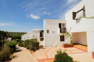 a view of a white house with a balcony at Apartamentos Sa Cornisa in Cala Morell