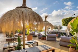 een patio met tafels, stoelen en parasols bij Barceló Tenerife Royal Level in San Miguel de Abona