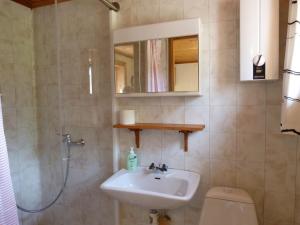 een badkamer met een wastafel, een toilet en een spiegel bij Stuga Sörgarden in Åsenhöga