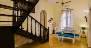 sala de estar con escalera y piano en GR STAYs Private Pool Villa in Calangute 5 mins to Baga, en Arpora
