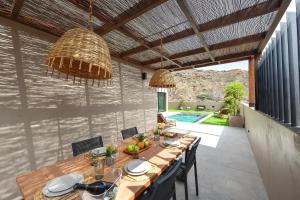 ein Esszimmer mit einem Holztisch und Stühlen in der Unterkunft Almadies Tauro by VillaGranCanaria in Mogán