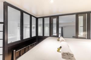 Habitación con ventanas de cristal y cama con manta. en GuestReady - Modern Duplex in Bourse - Sentier, en París