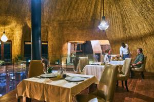 ein Restaurant mit zwei Tischen, an denen die Leute sitzen in der Unterkunft Desert Hills Lodge in Sesriem