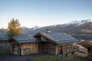 une cabane en rondins avec des montagnes en arrière-plan dans l'établissement Bolquère I Chalet Boolly 5 étoiles luxe et bois I Vue montagne, à Bolquère-Pyrénées 2000