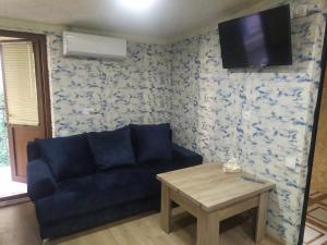 uma sala de estar com um sofá azul e uma mesa em COZY HOTEL SKS em Yerevan