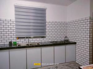 a kitchen with a sink and a window at Homestay Tengku Maheran in Jitra