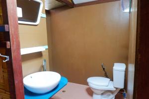 a bathroom with a toilet and a sink at Bamboo Bungalows in Ko Phayam