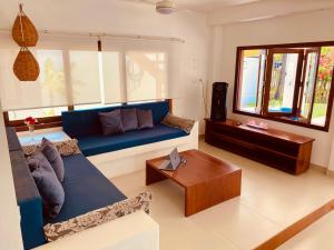un soggiorno con un divano blu e un tavolo di VILLA TROPICAL LUX a Pipa
