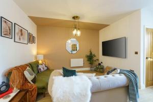a living room with a couch and a tv at Bressingham - 2 Bedroom Luxury Apartment by Mint Stays in Bristol