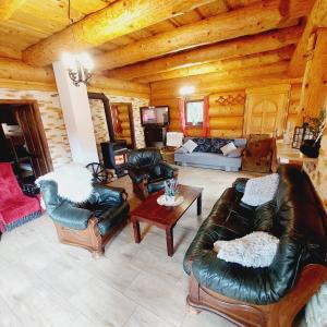 a living room with leather furniture in a log cabin at Kanadský zrub in Prievidza
