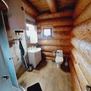 a bathroom in a log cabin with a toilet and a sink at Kanadský zrub in Prievidza