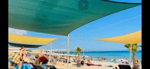 a group of people on the beach under a large umbrella at Baia San Lorenzo in Reitani