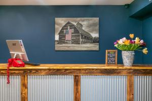a counter with a picture of a barn with a vase of flowers at Mad River Lodge in Waitsfield